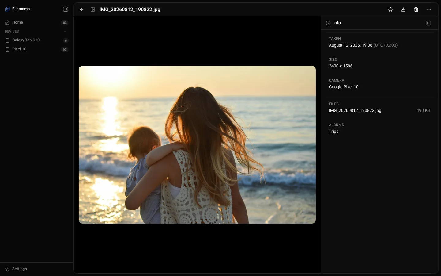 Filamama photo view: a mother holding a child at a sunset beach, with an info panel showing date taken, size, camera, file name and the Trips album